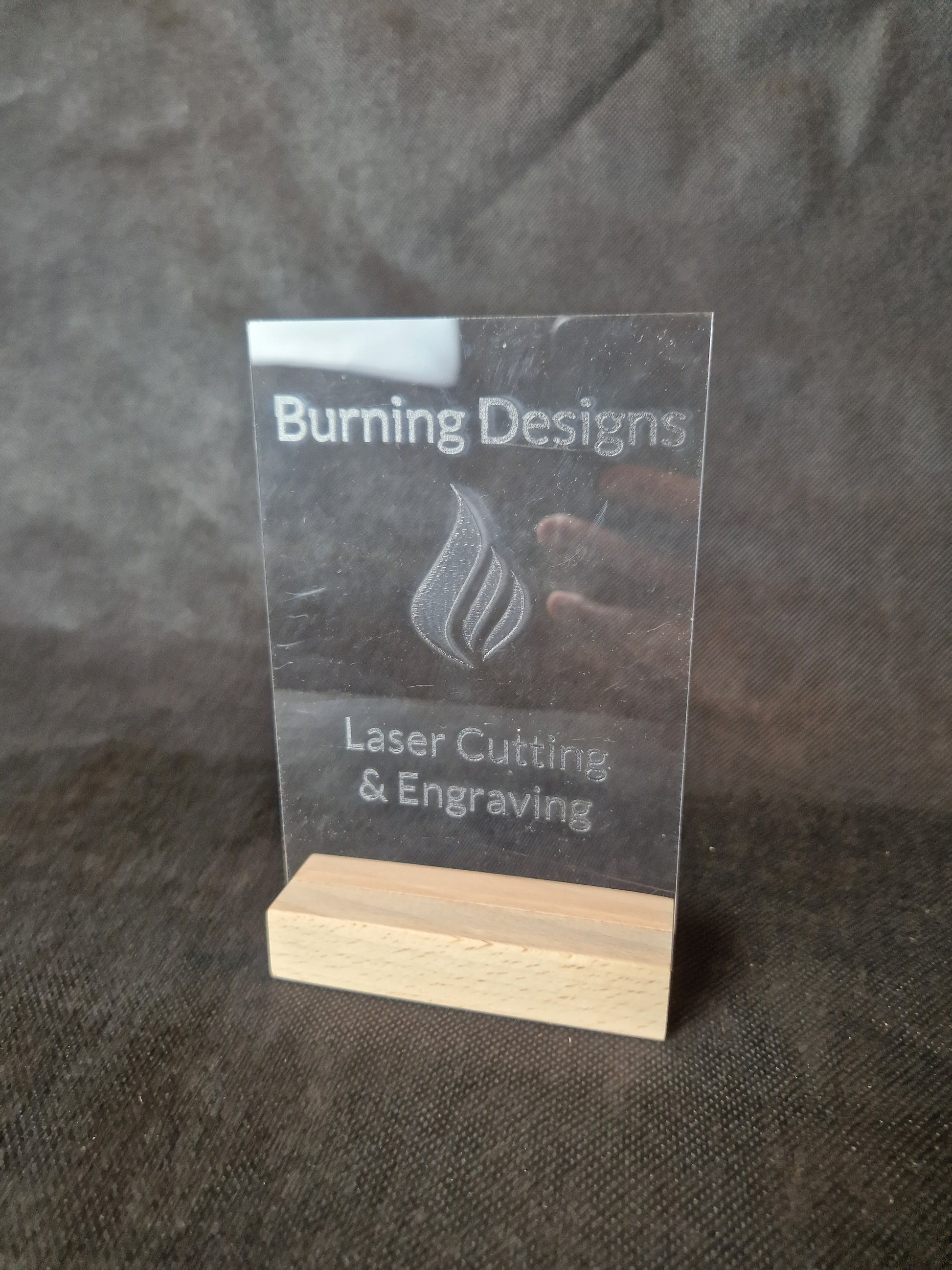 Clear acrylic display stand with custom laser engraved text and modern design