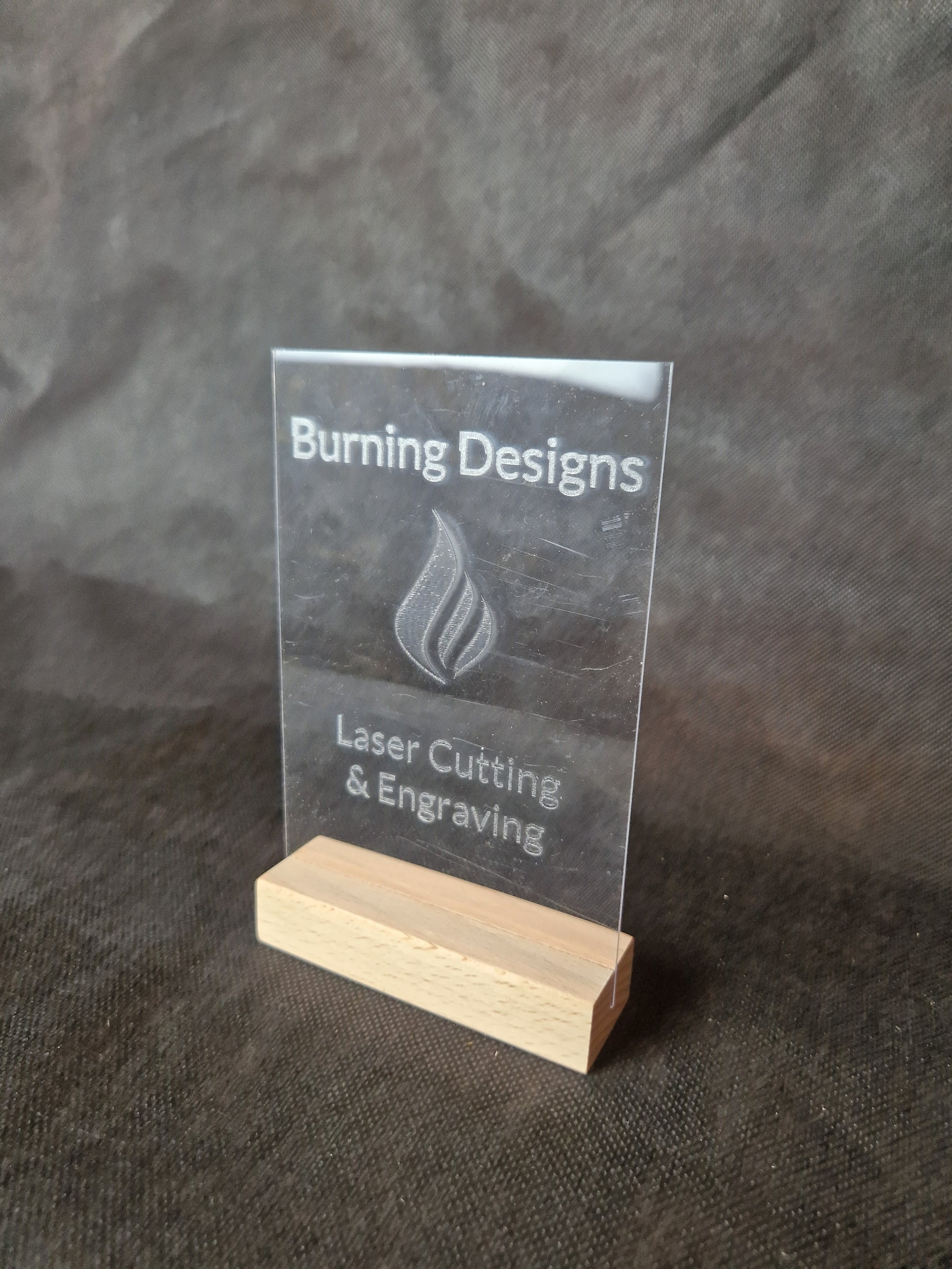 Clear acrylic display stand with custom laser engraved text and modern design