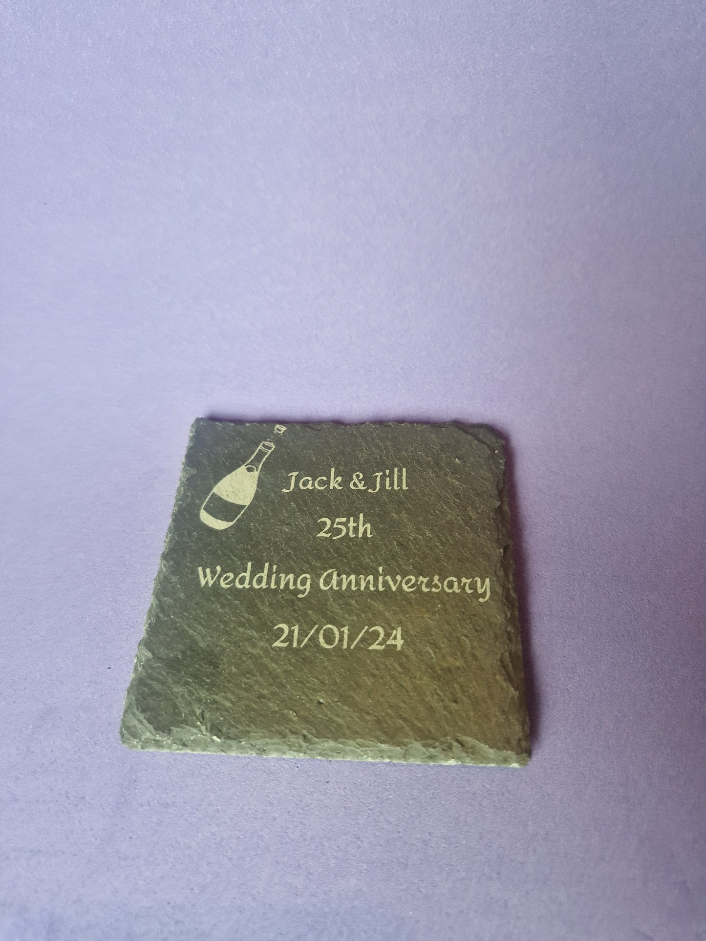 Natural black slate drink coaster with custom laser engraved design and protective feet