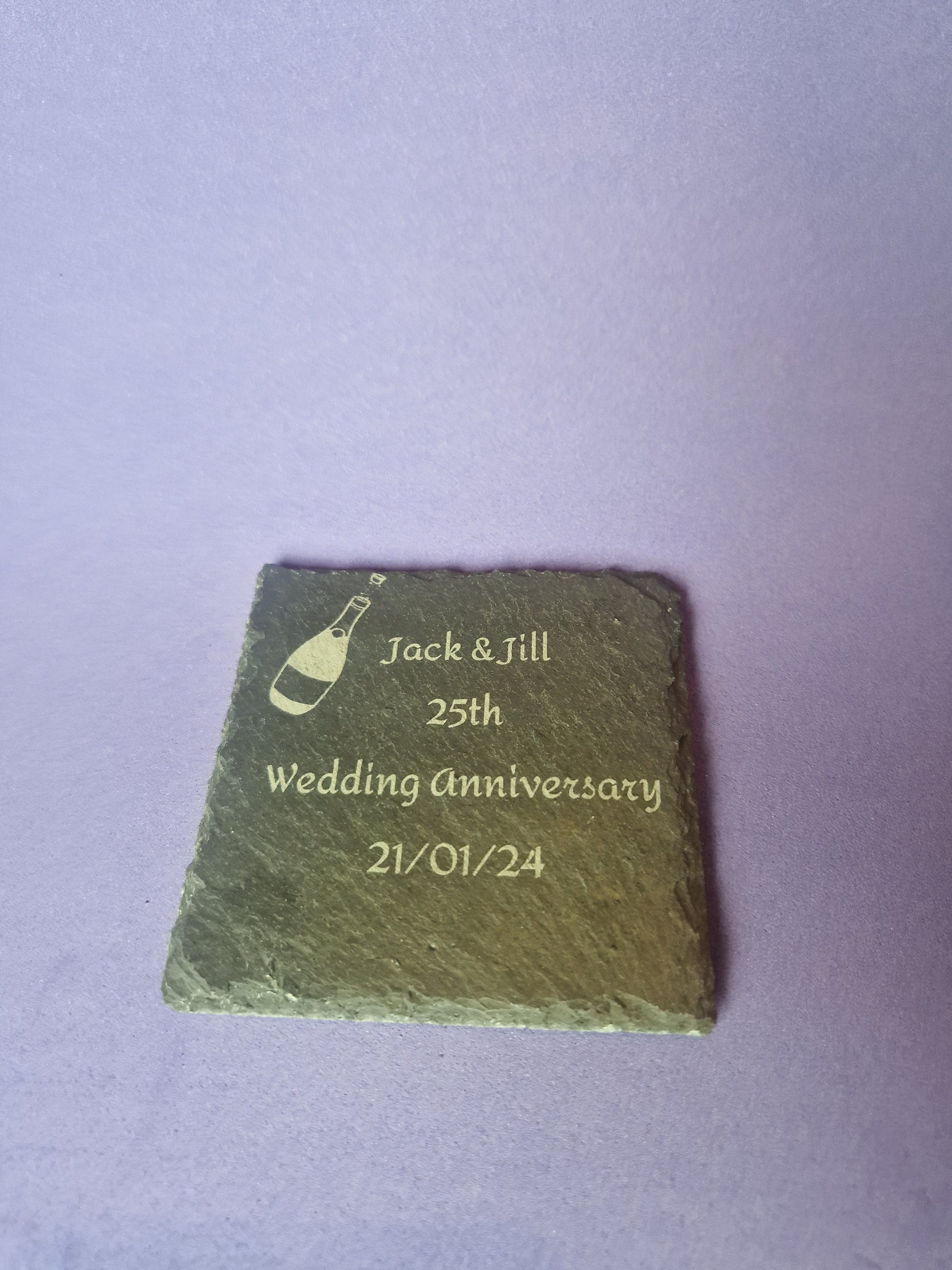Natural black slate drink coaster with custom laser engraved design and protective feet