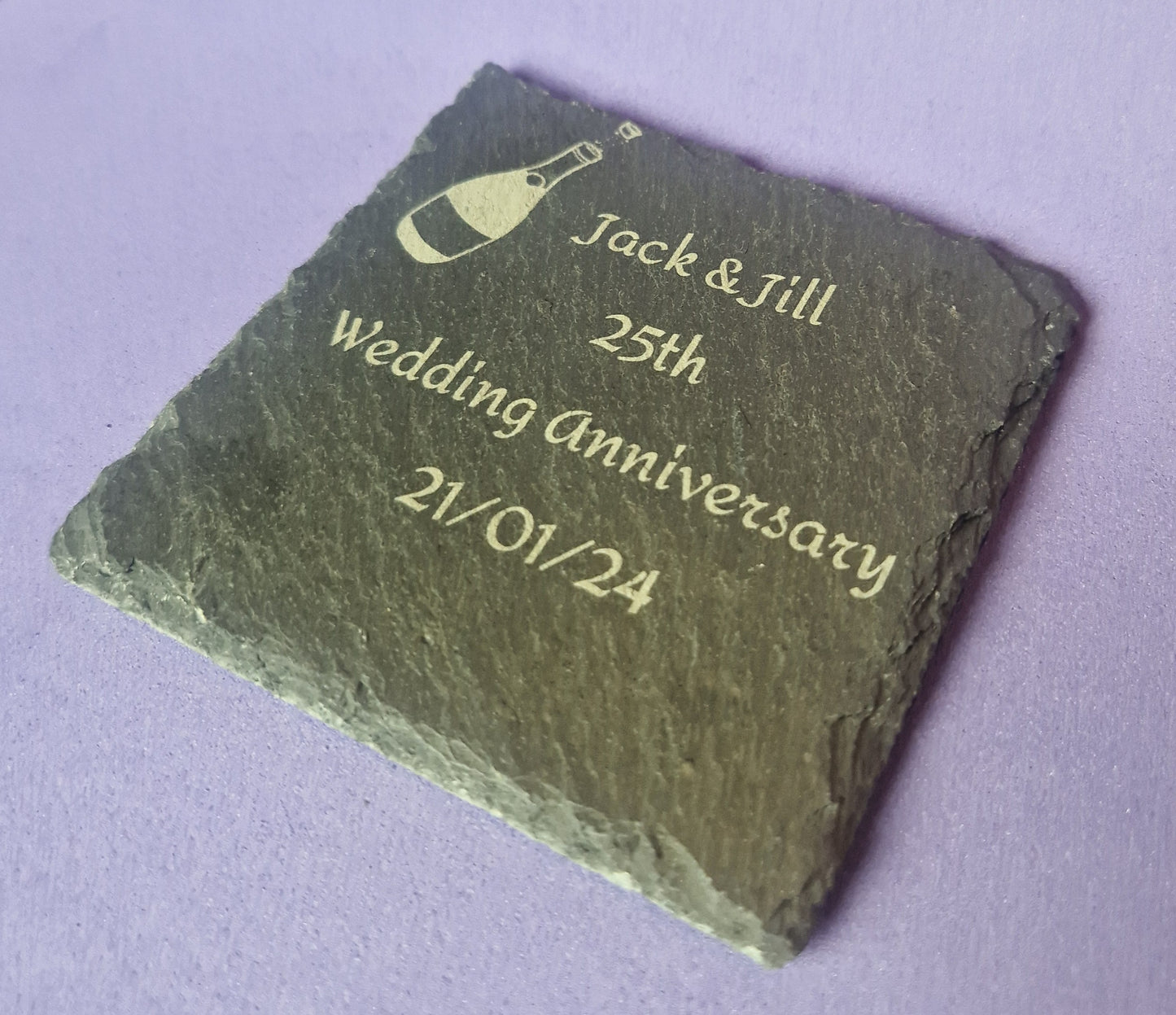 Natural black slate drink coaster with custom laser engraved design and protective feet