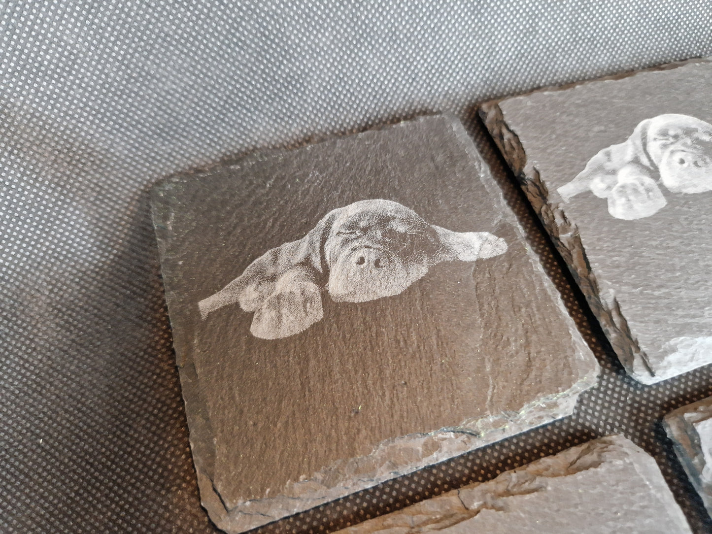 Natural black slate drink coaster with custom laser engraved design and protective feet