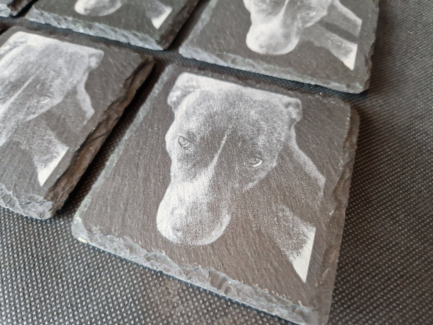 Natural black slate drink coaster with custom laser engraved design and protective feet