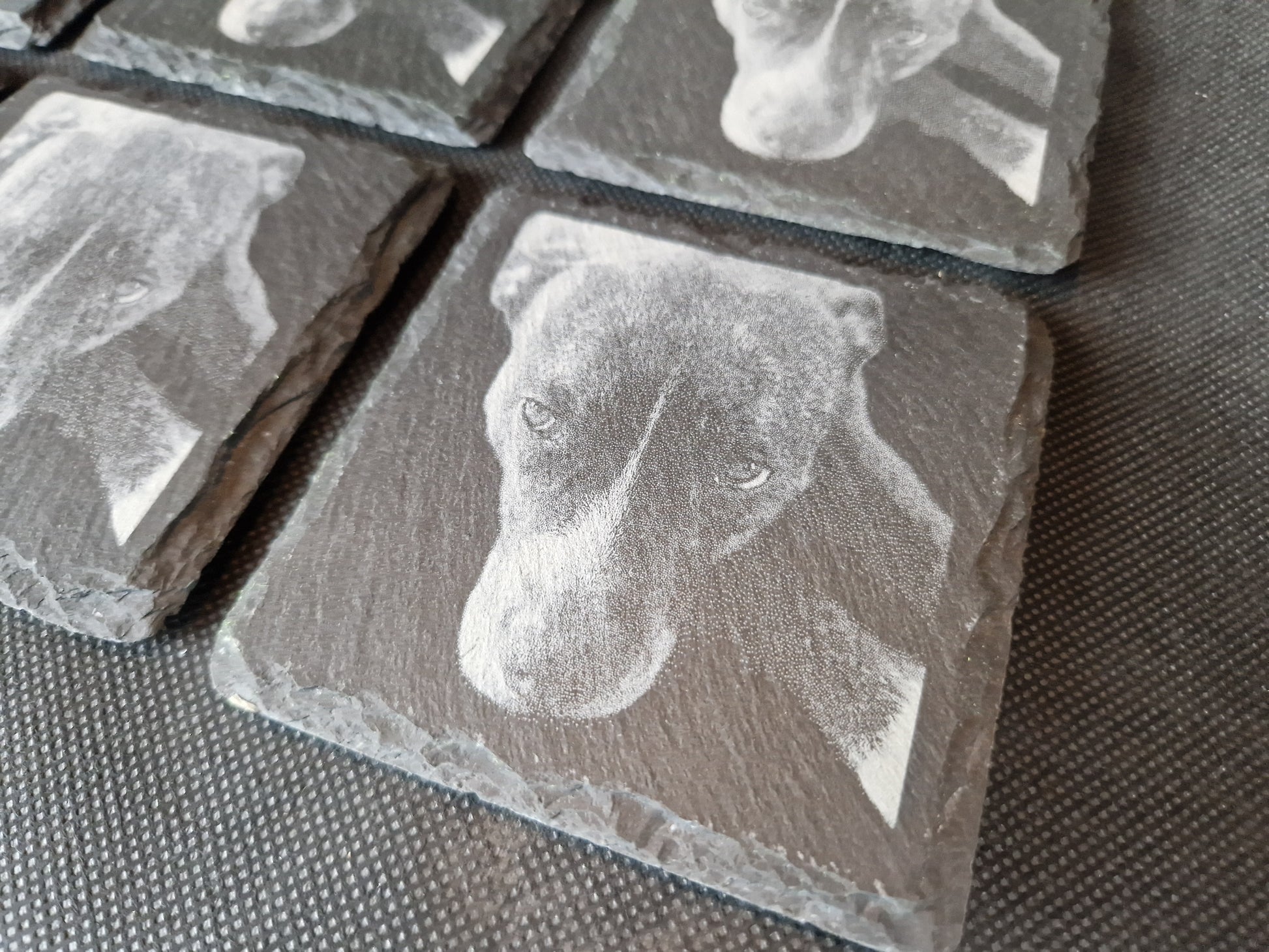Natural black slate drink coaster with custom laser engraved design and protective feet