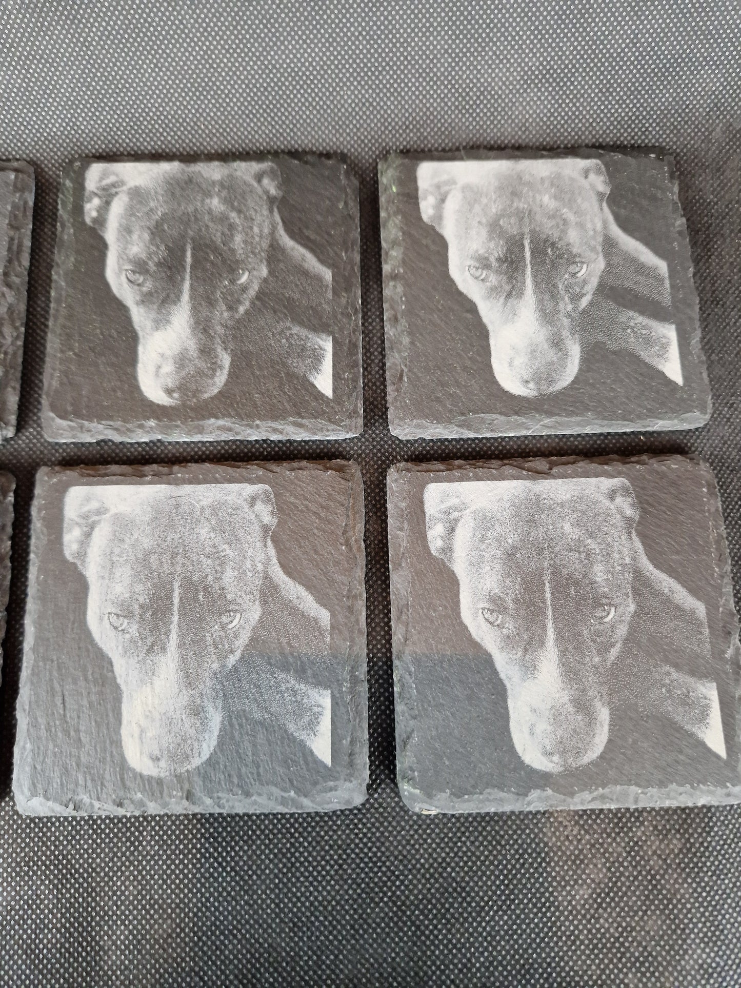 Natural black slate drink coaster with custom laser engraved design and protective feet