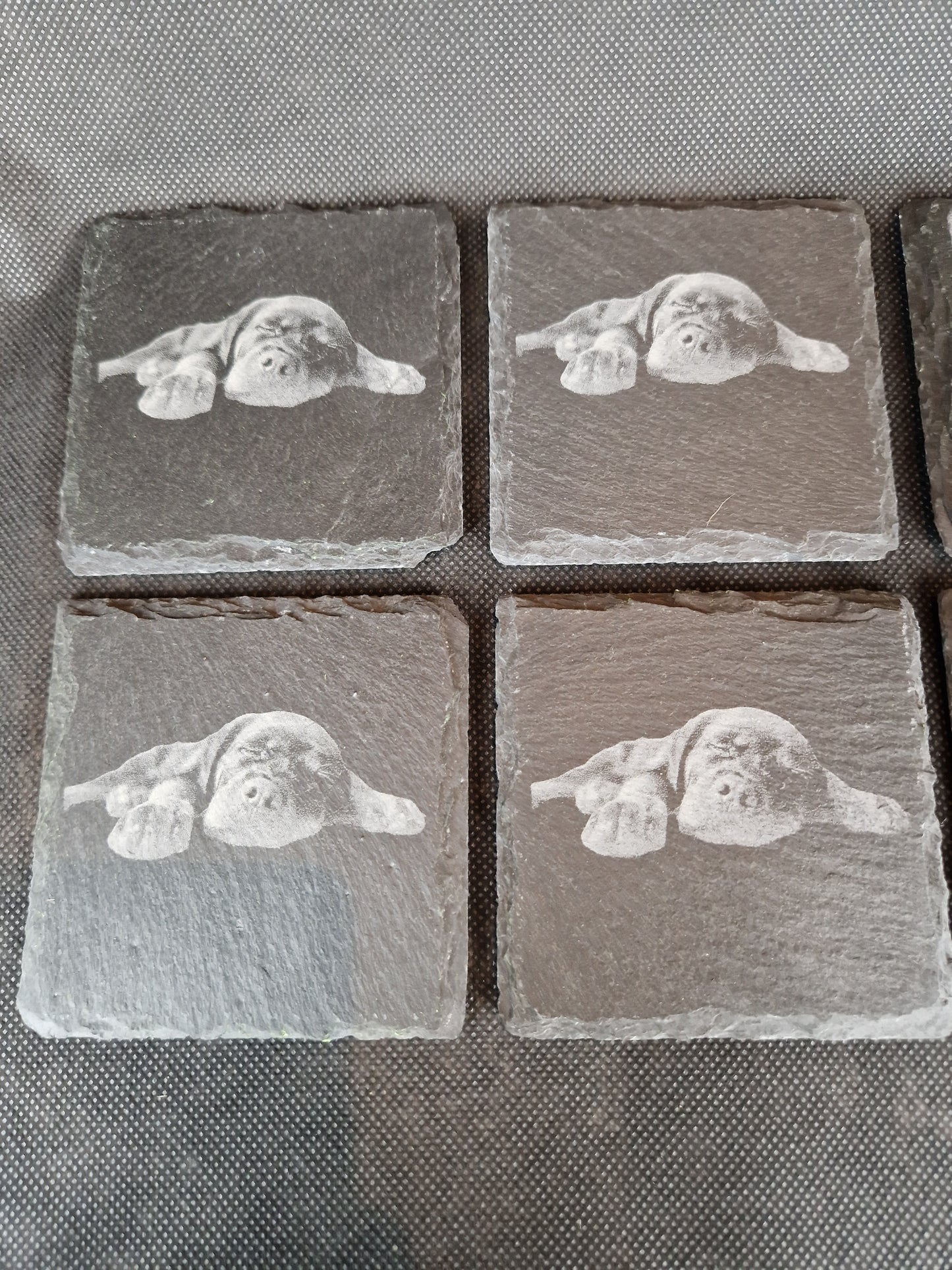 Natural black slate drink coaster with custom laser engraved design and protective feet