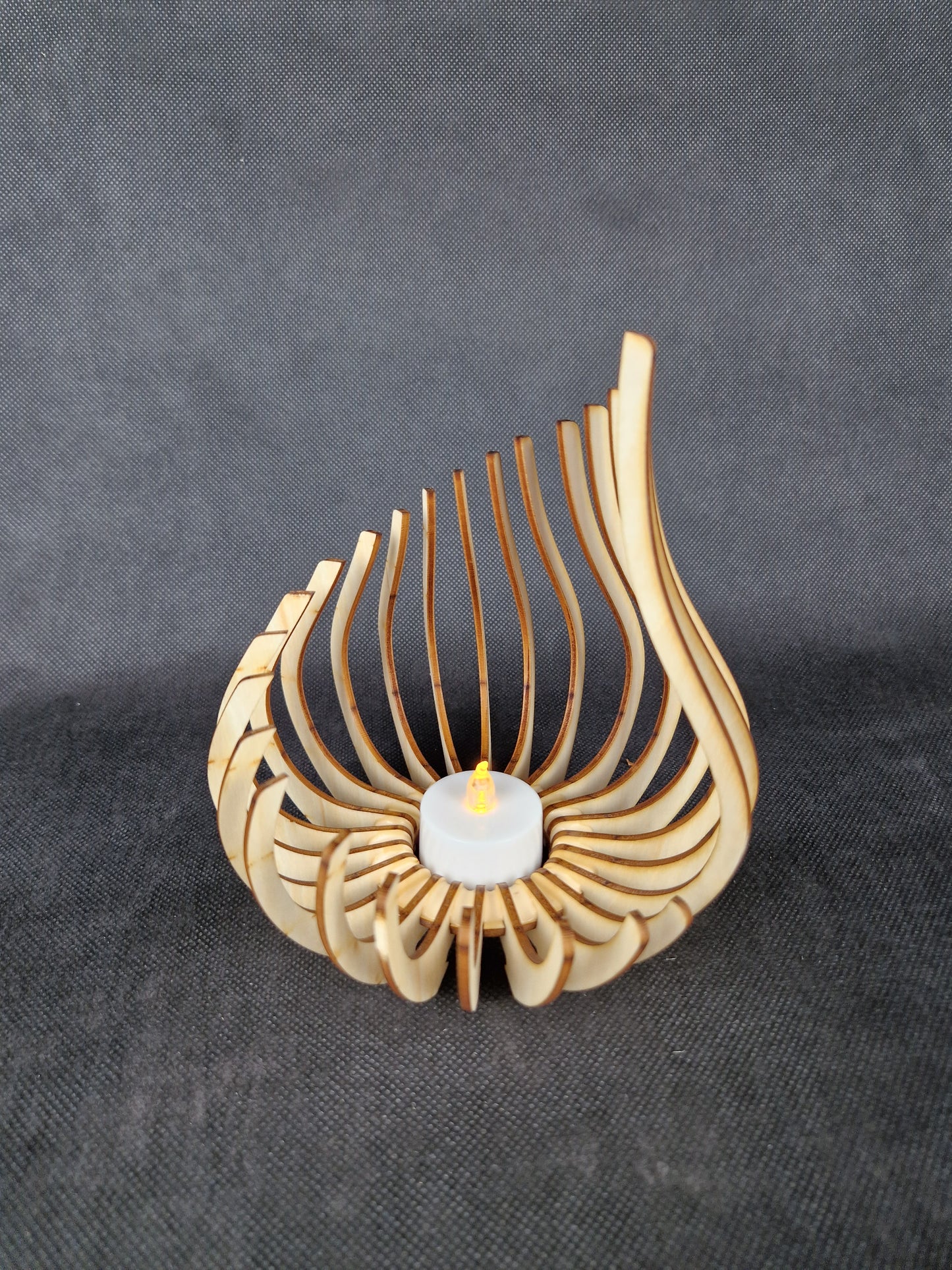 Modern geometric wooden tea light holder with intricate laser cut pattern creating light shadows