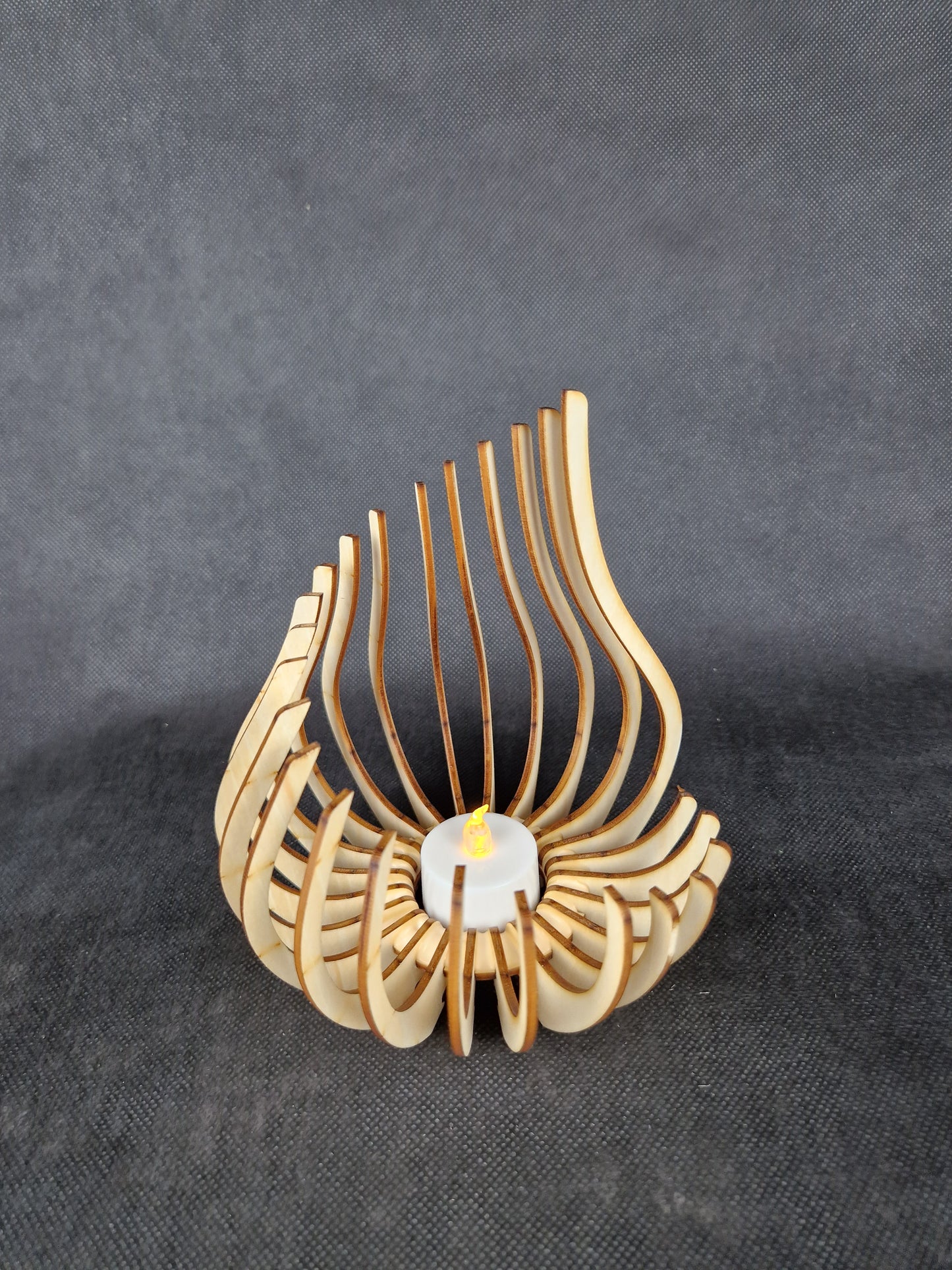 Modern geometric wooden tea light holder with intricate laser cut pattern creating light shadows