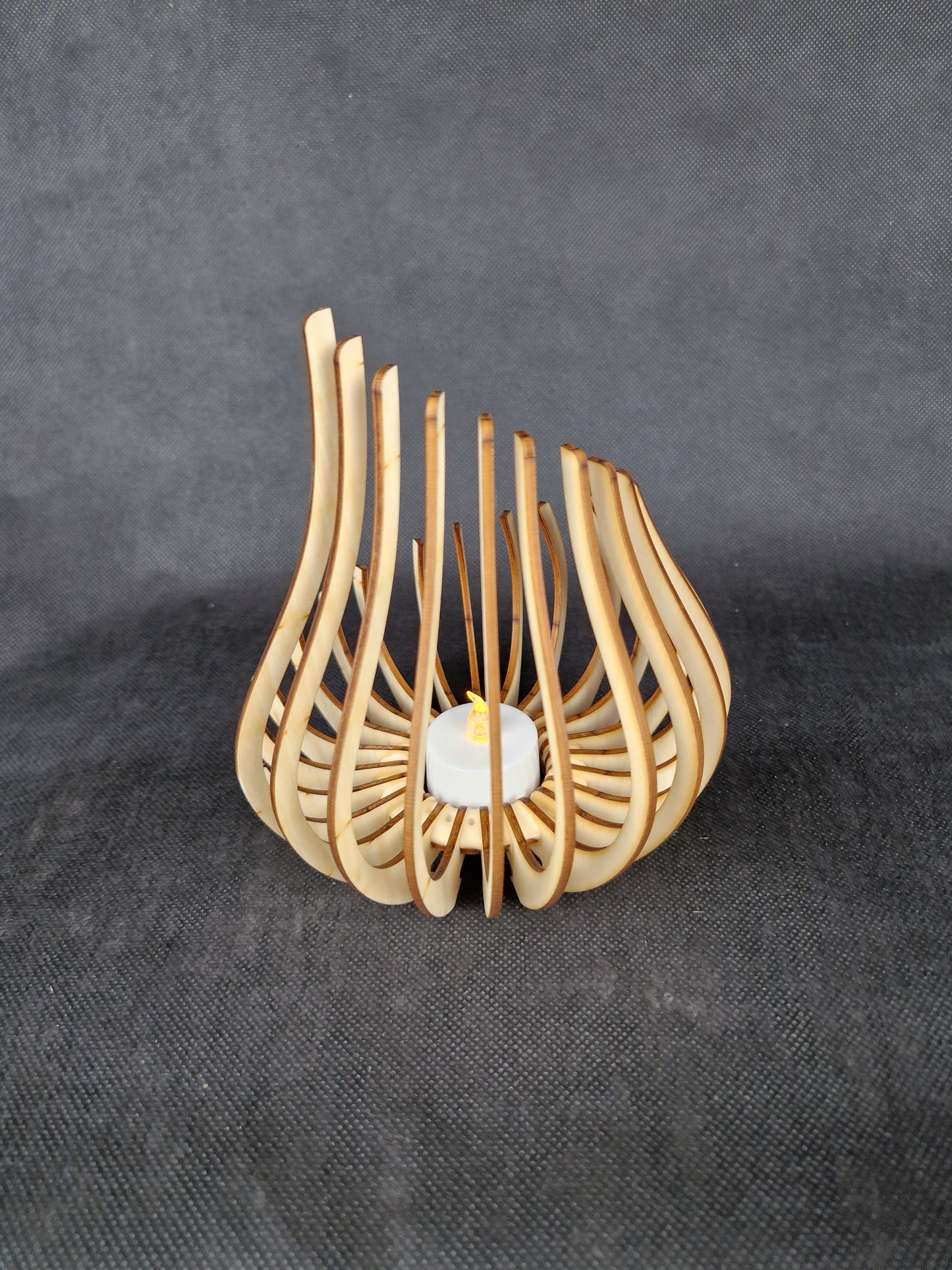 Modern geometric wooden tea light holder with intricate laser cut pattern creating light shadows