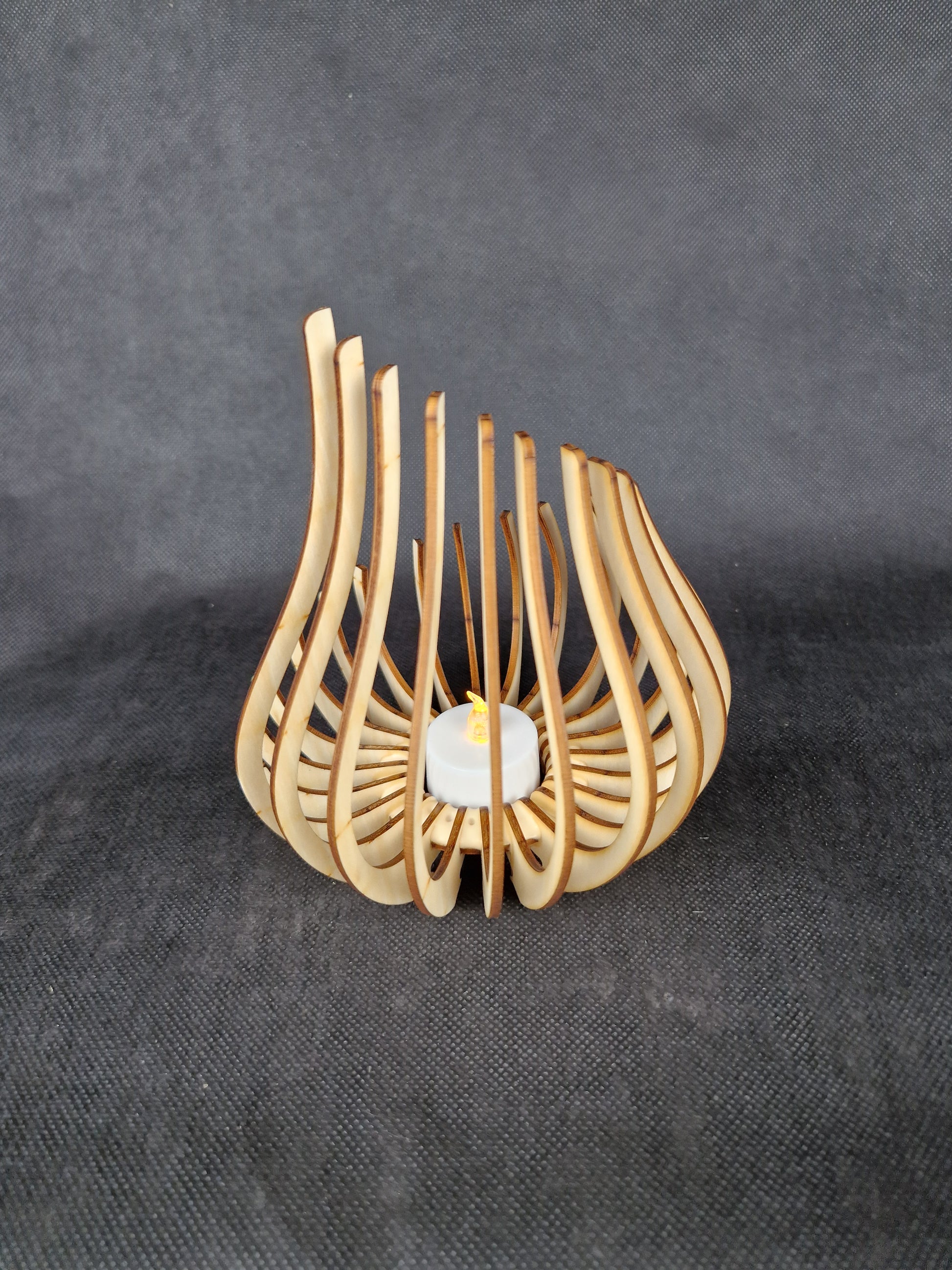 Modern geometric wooden tea light holder with intricate laser cut pattern creating light shadows
