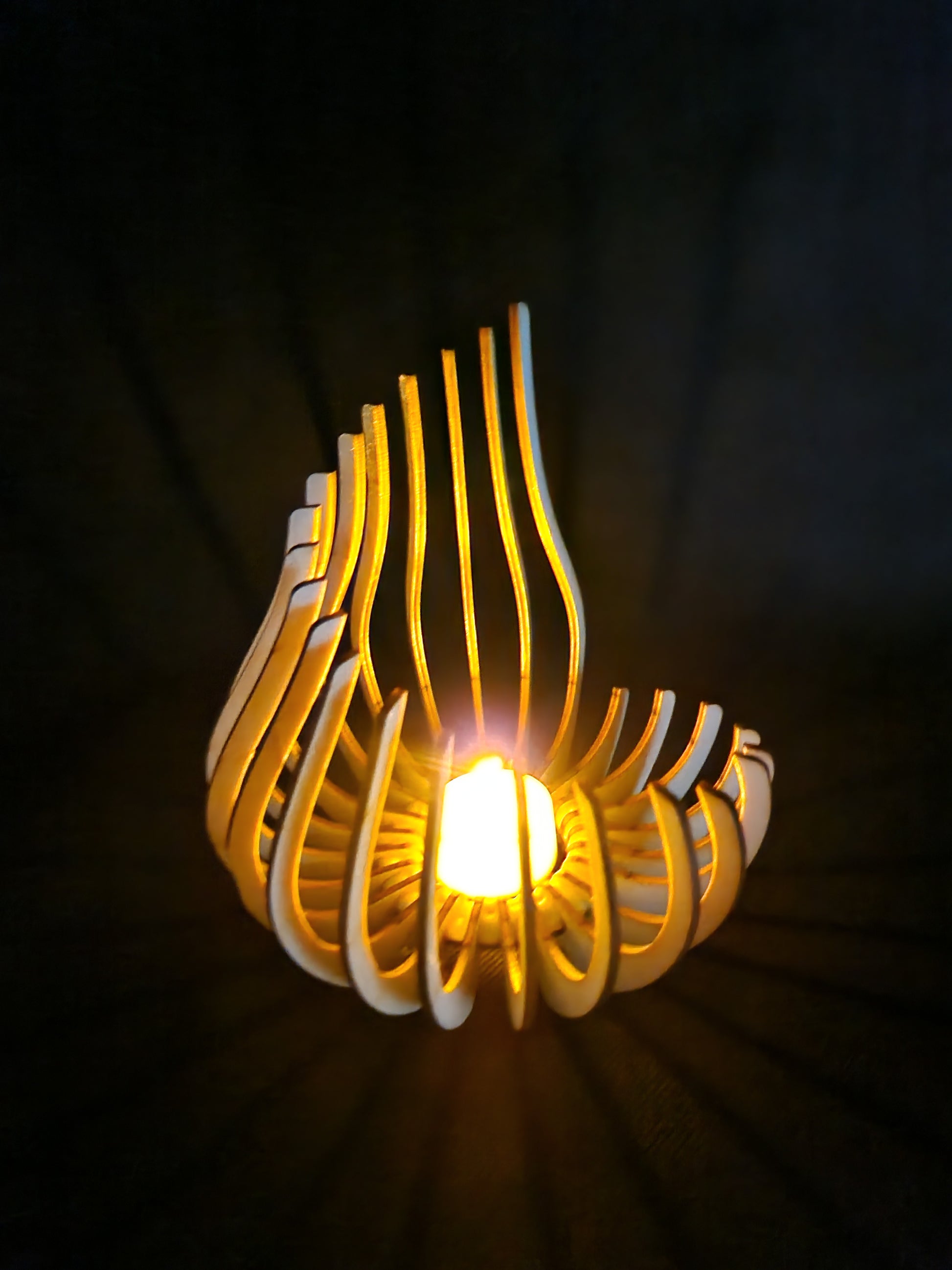 Modern geometric wooden tea light holder with intricate laser cut pattern creating light shadows