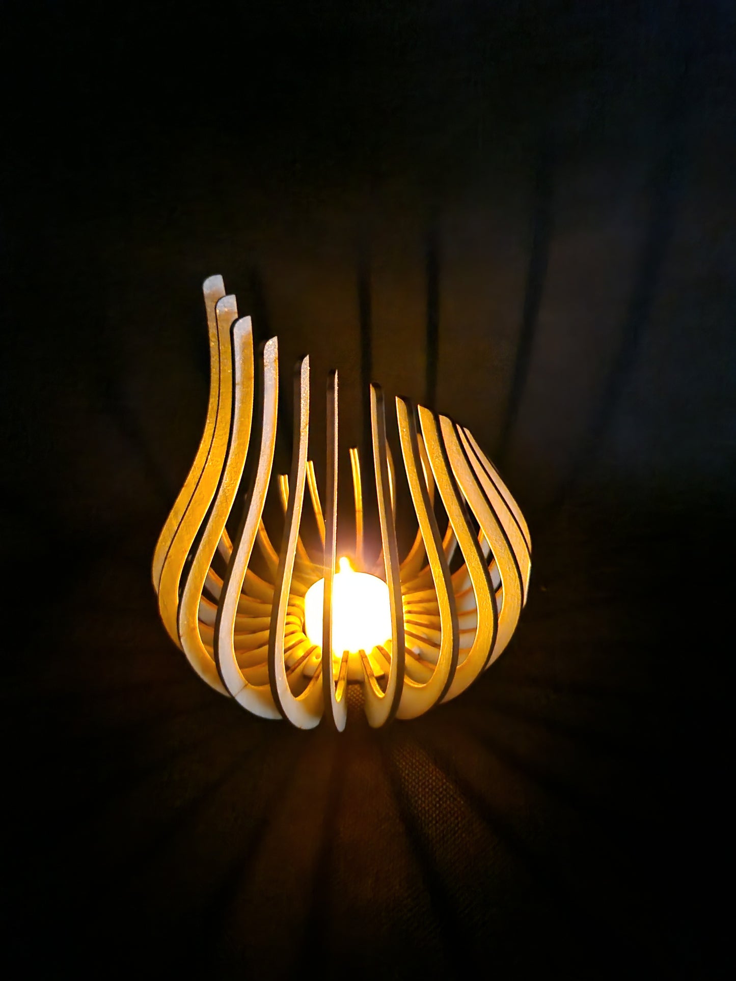 Modern geometric wooden tea light holder with intricate laser cut pattern creating light shadows