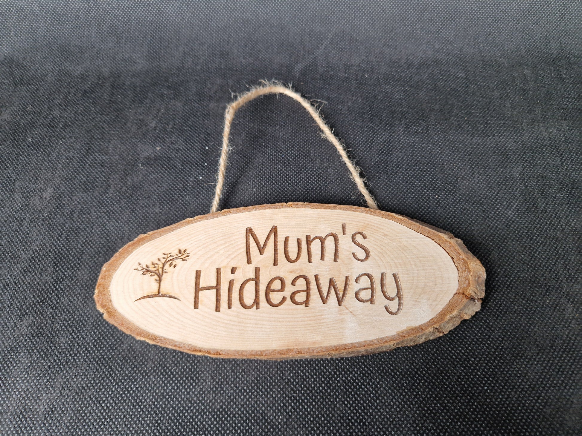 Natural wood slice hanging sign with rustic laser engraved text and jute rope hanger
