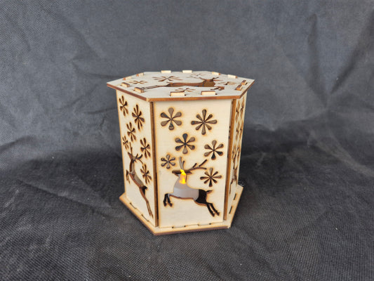 Wooden silhouette Christmas lamp with laser cut festive scene creating shadow effects