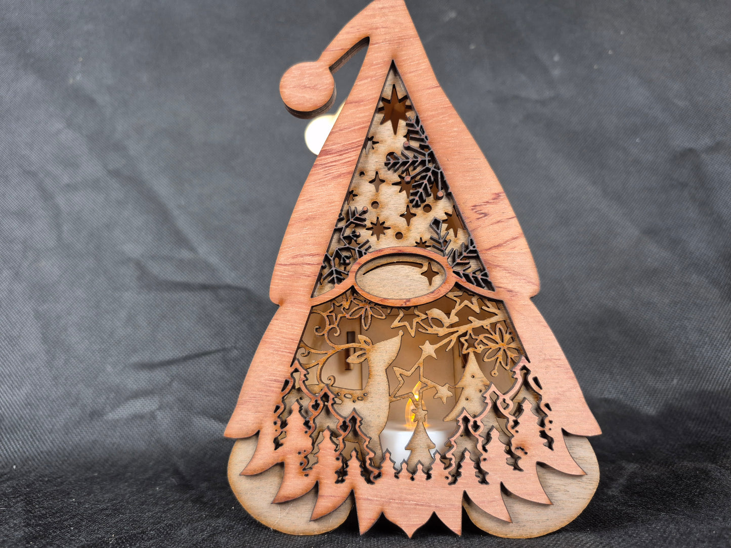 Illuminated wooden Gonk lamp with layered laser cut design and warm LED lighting