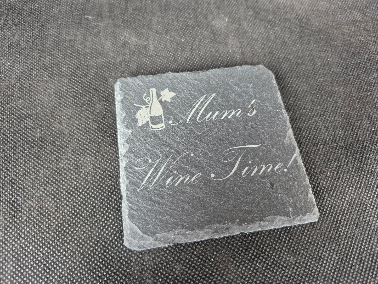 Natural black slate drink coaster with custom laser engraved design and protective feet