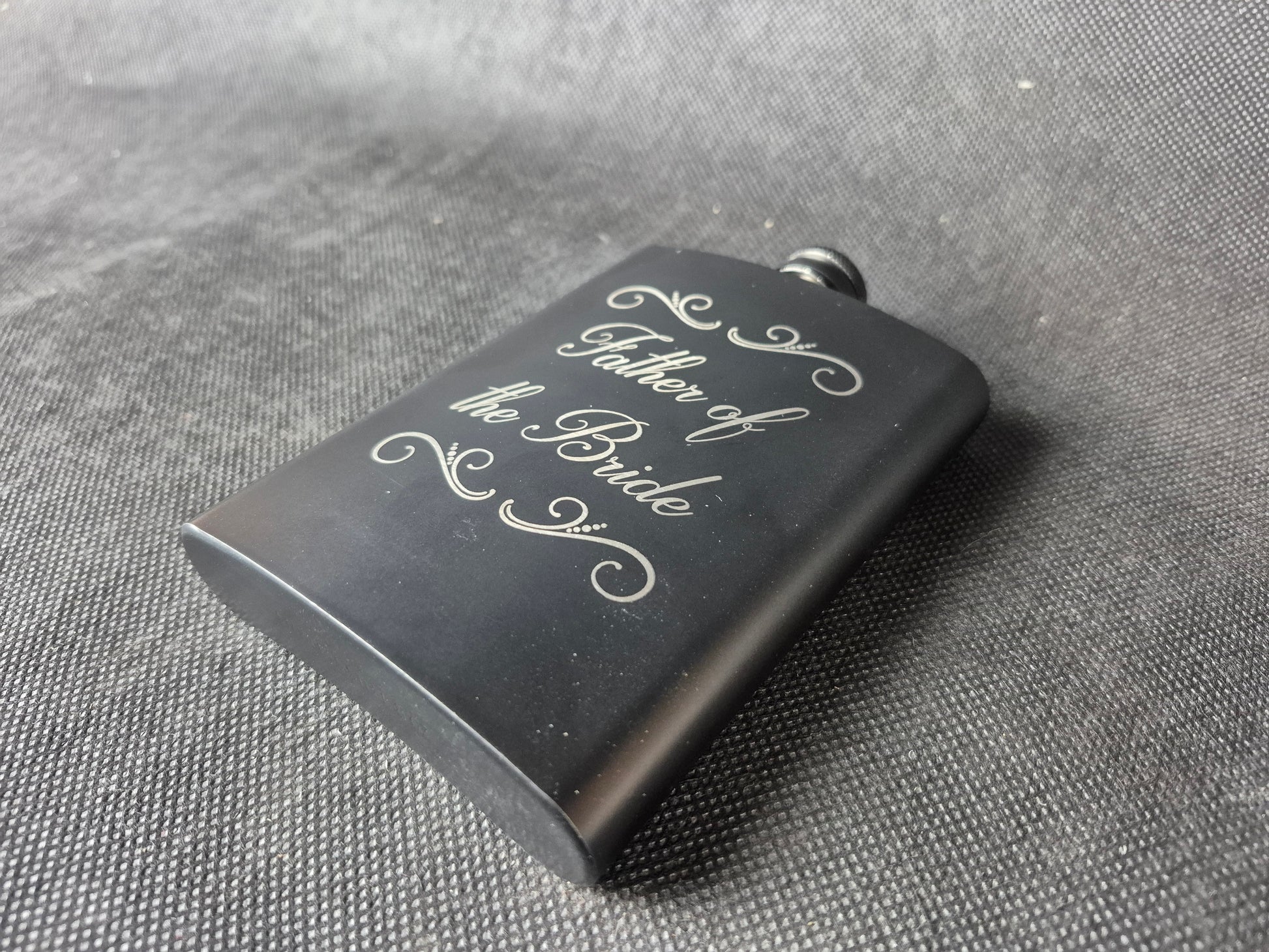 Stainless steel hip flask with personalized laser engraved message and brushed metal finish