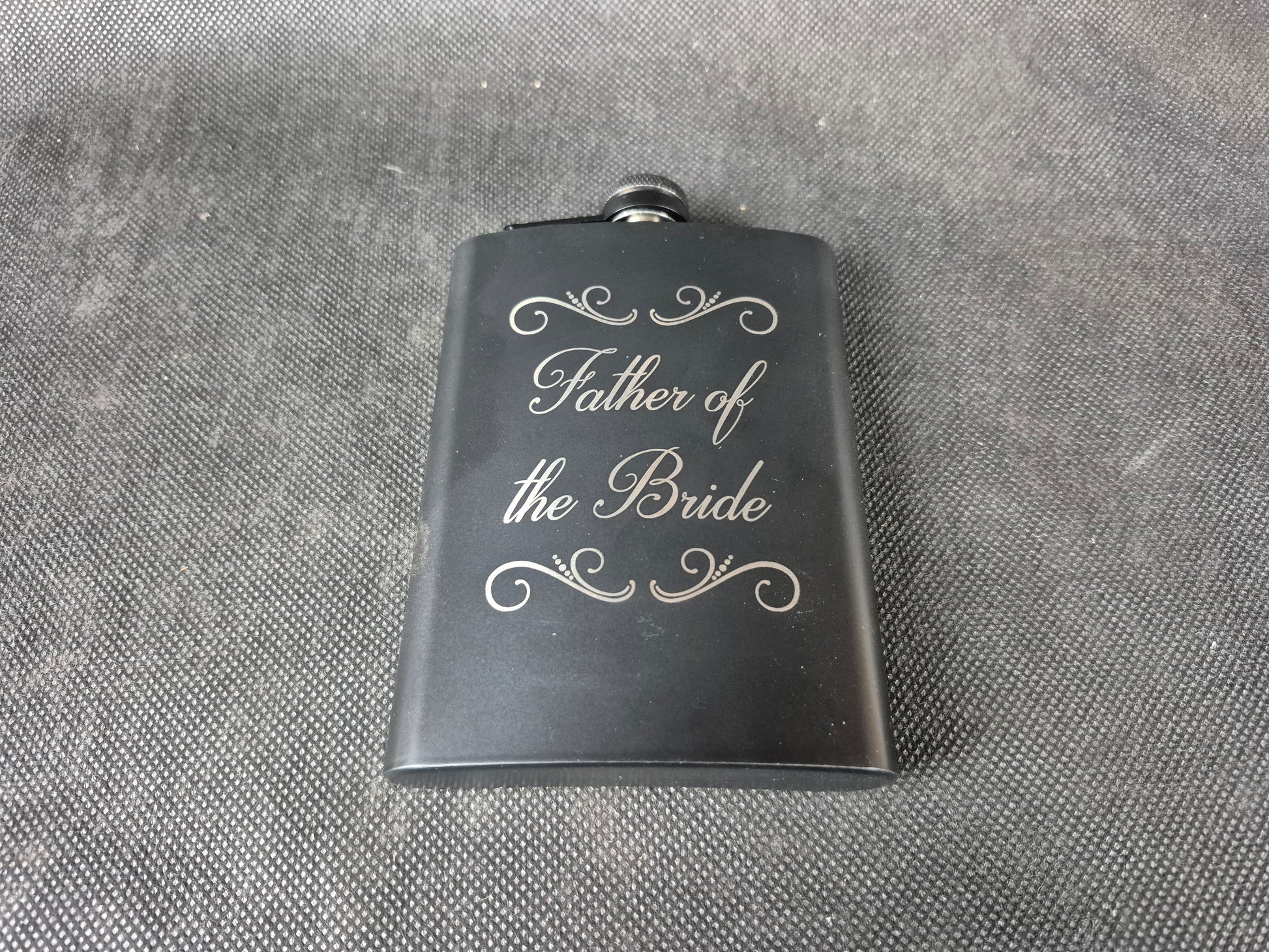 Stainless steel hip flask with personalized laser engraved message and brushed metal finish