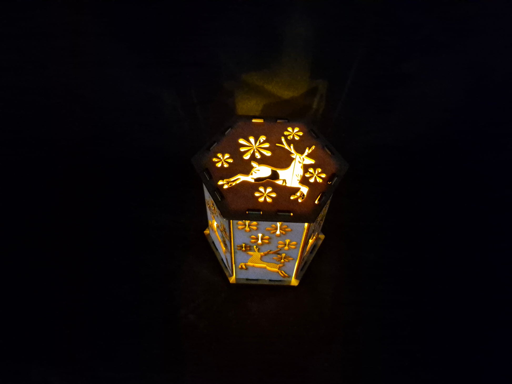 Wooden silhouette Christmas lamp with laser cut festive scene creating shadow effects