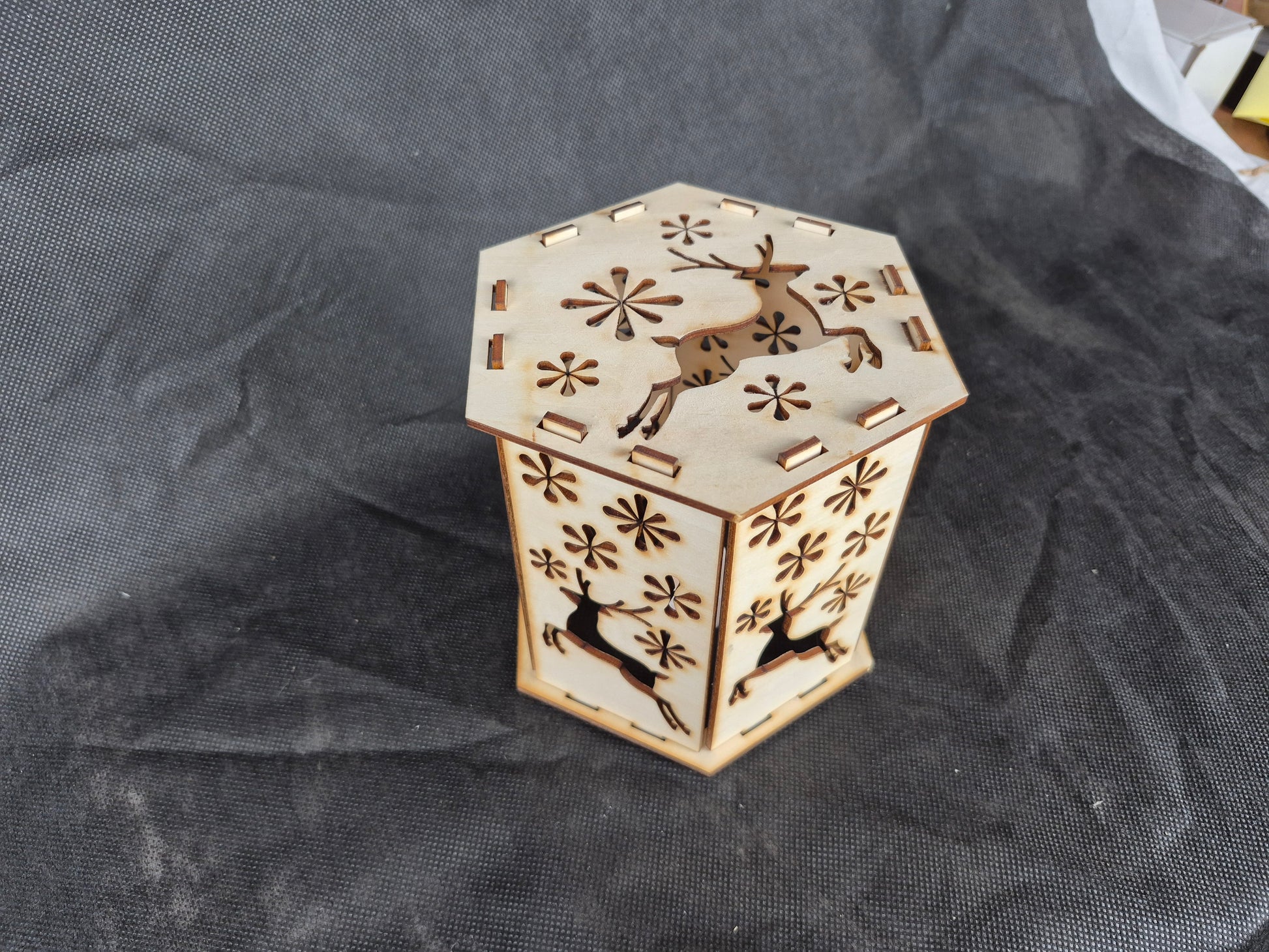 Wooden silhouette Christmas lamp with laser cut festive scene creating shadow effects