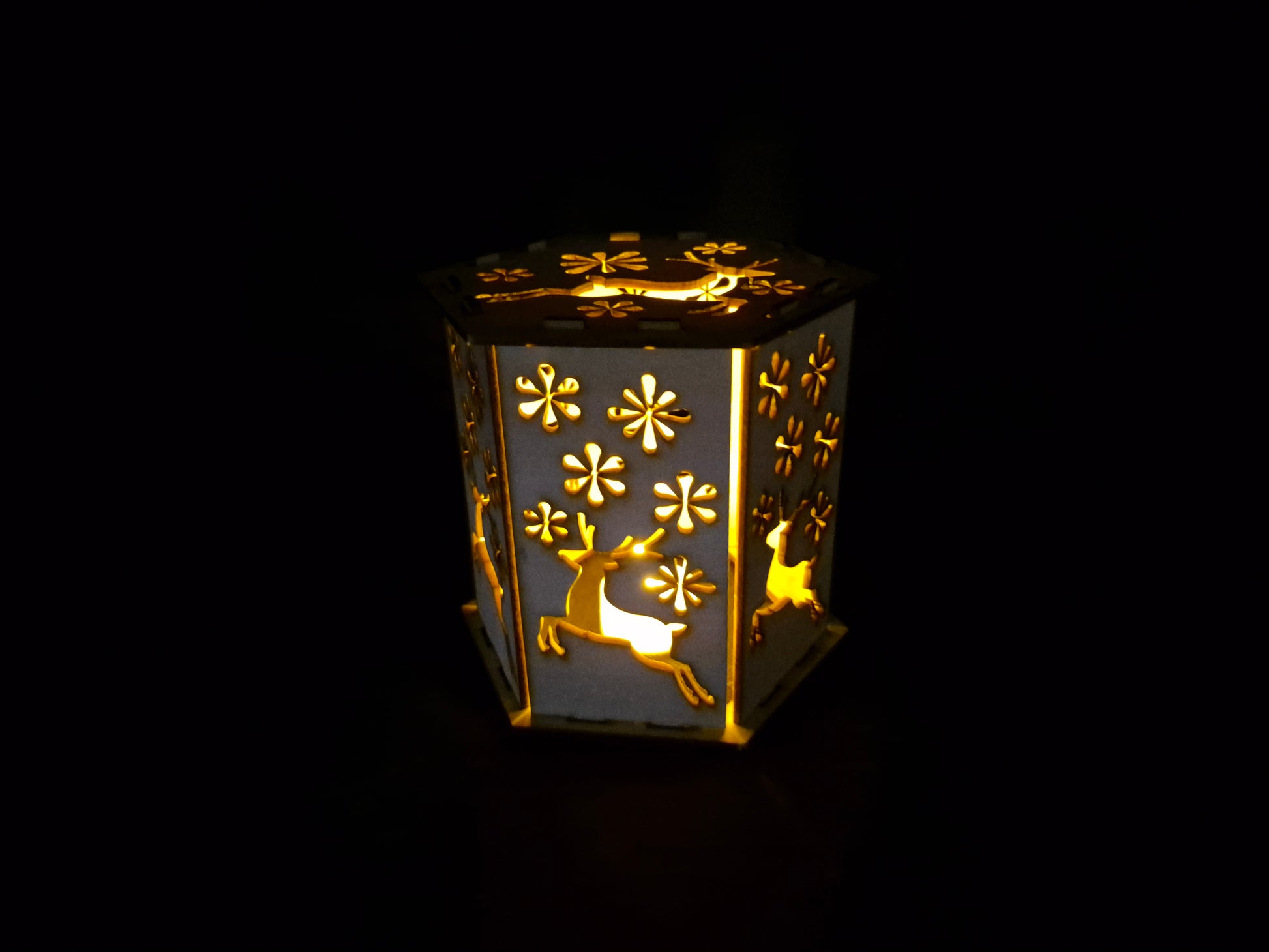 Wooden silhouette Christmas lamp with laser cut festive scene creating shadow effects