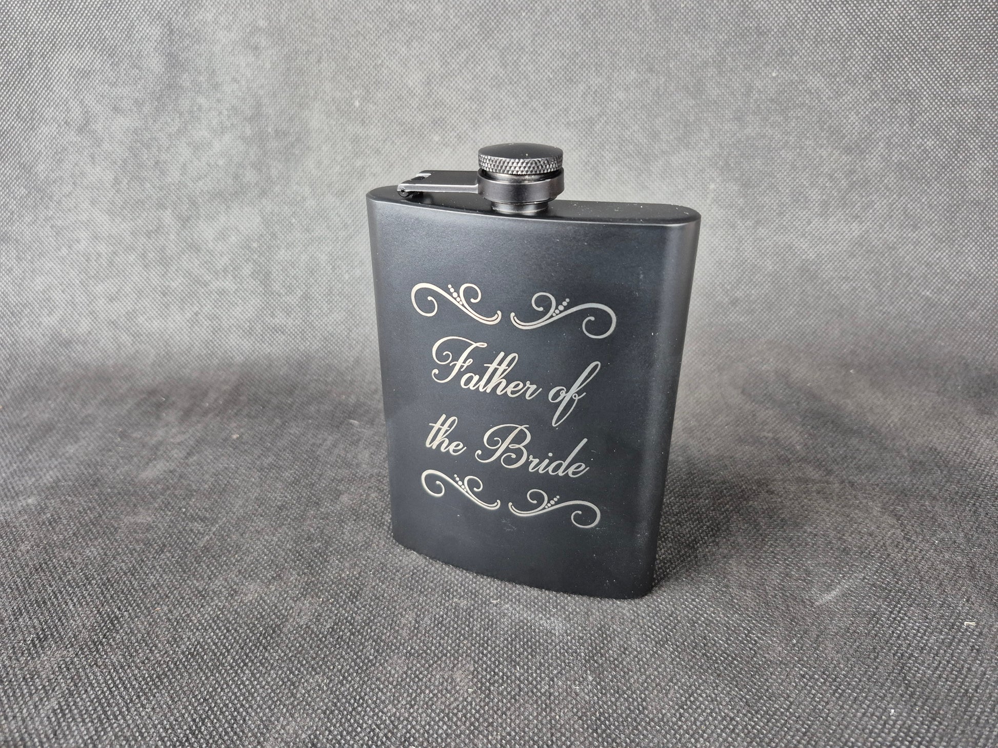 Stainless steel hip flask with personalized laser engraved message and brushed metal finish