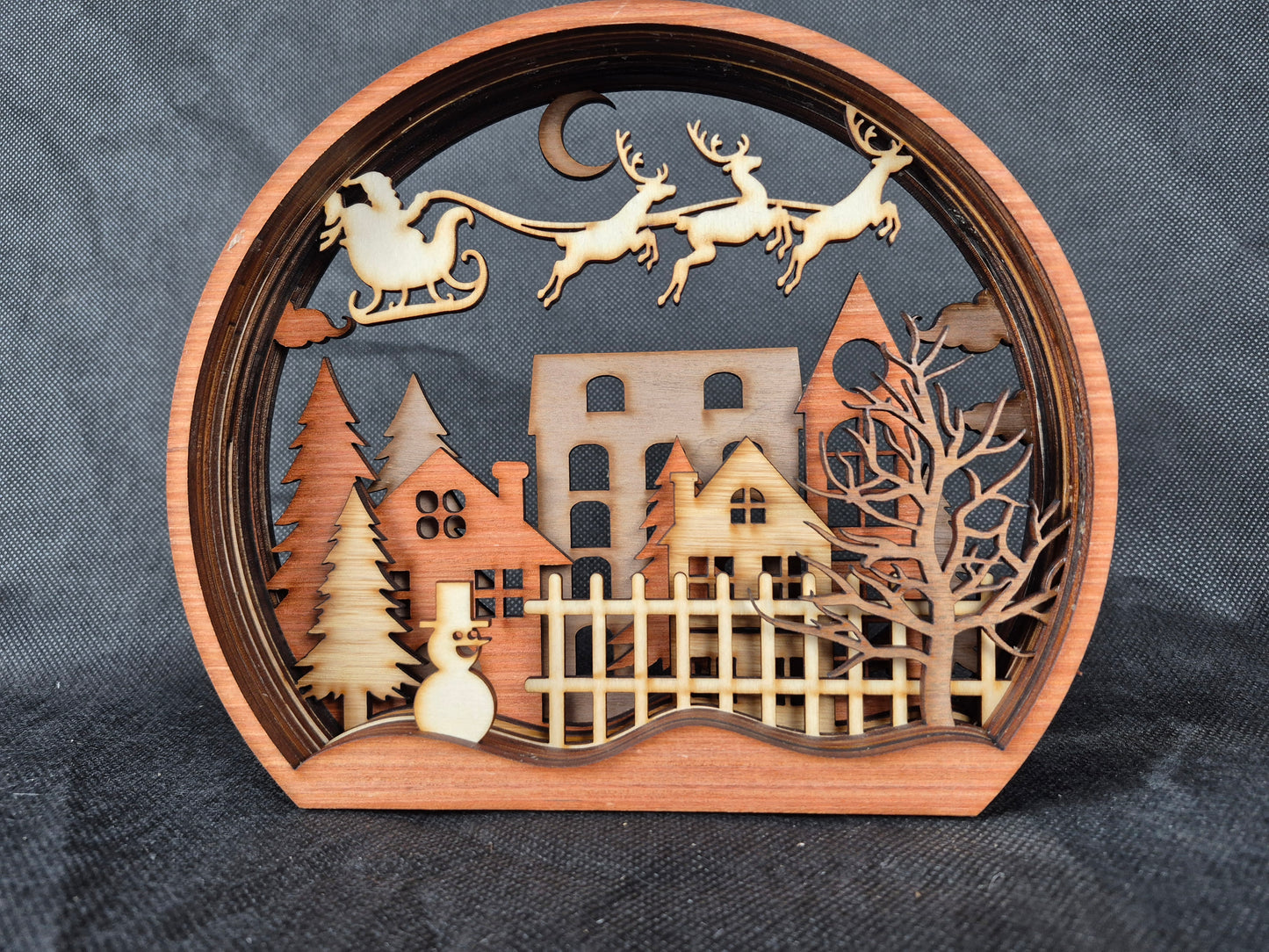 Multi-layered wooden Christmas display with intricate laser cut winter scene and stable base