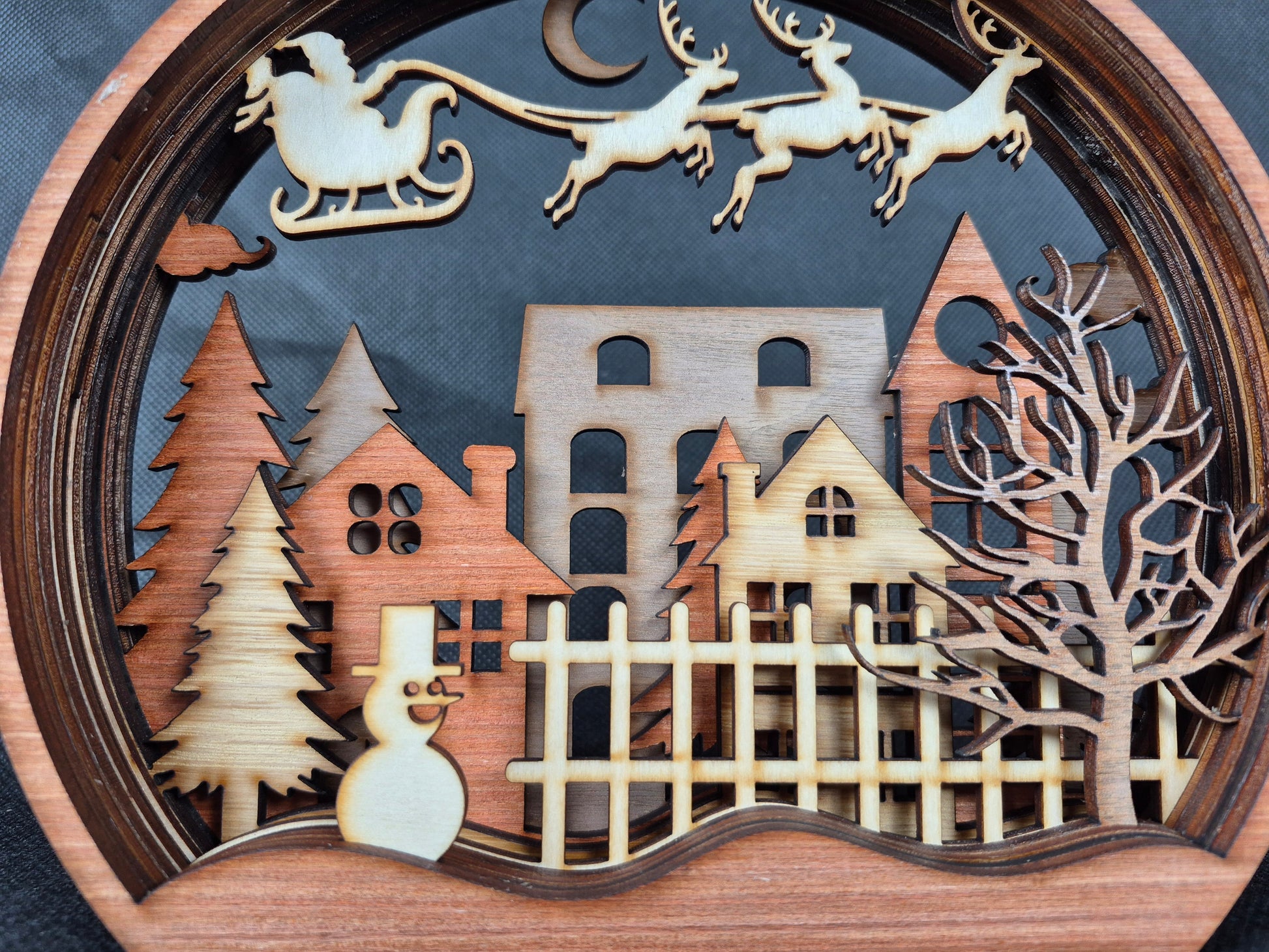 Multi-layered wooden Christmas display with intricate laser cut winter scene and stable base